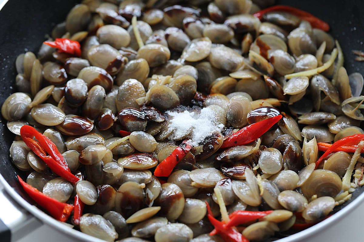 Stir frying lala clams and seasonings in the skillet. 