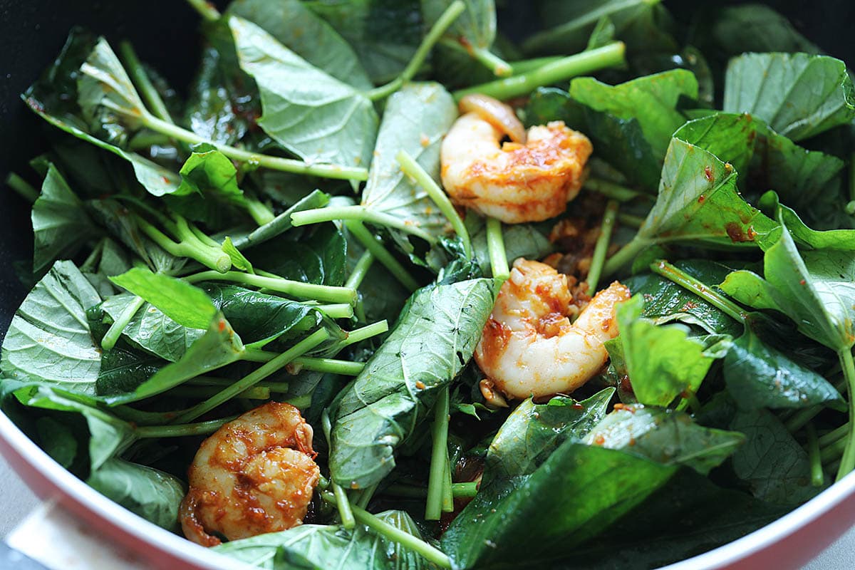 Sweet potato leaves with shrimp in a skillet.