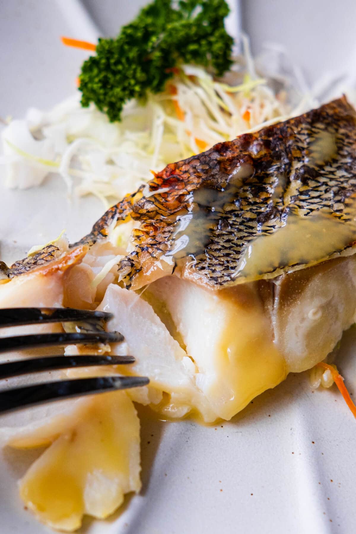 The flaky fish meat marinated in miso is poked by a fork. 