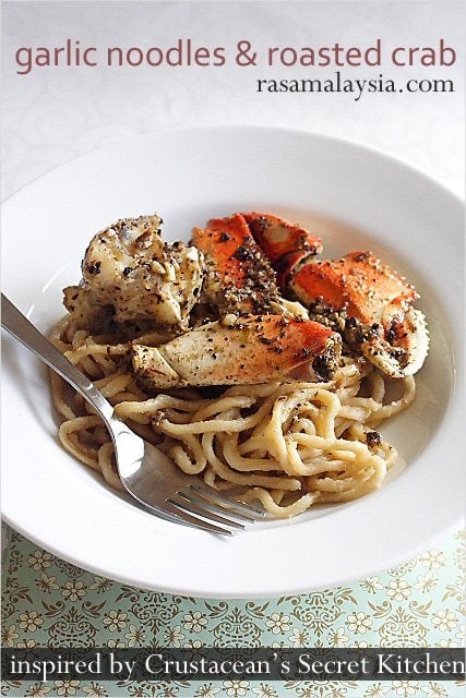 Garlic noodles and roasted crab served  in a plate with a fork.