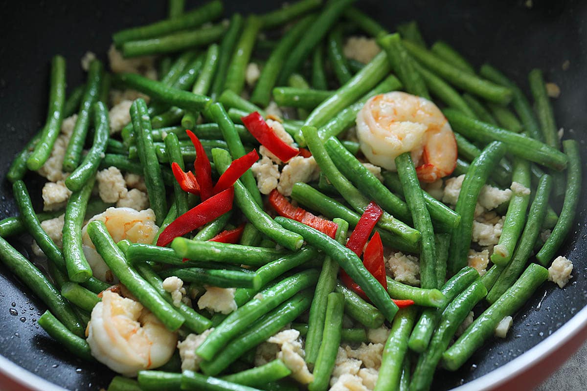 Stir fried Chinese long beans in a wok.