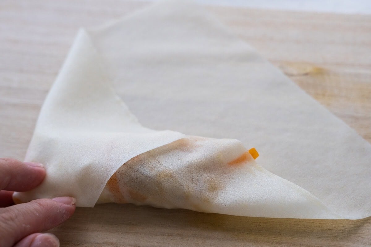 Add the filling to the center of the spring roll wrapper, then fold in the two sides and roll it up. 