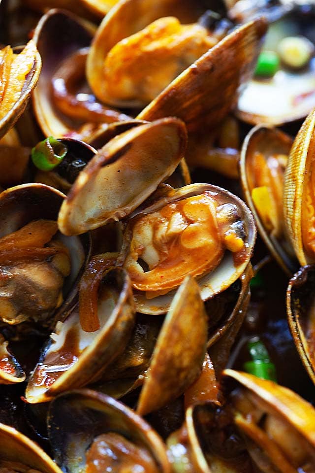 Curry clams in a skillet.