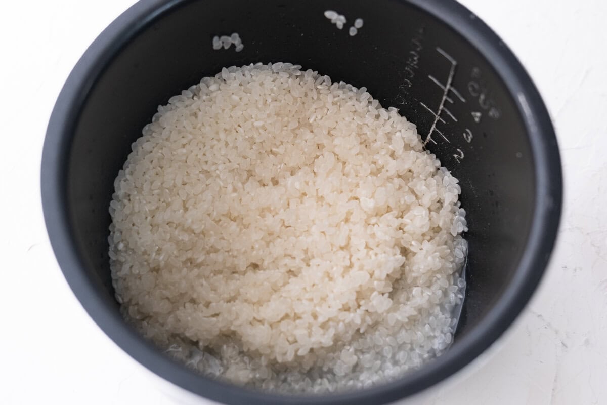 Washed rice in a rice cooker.