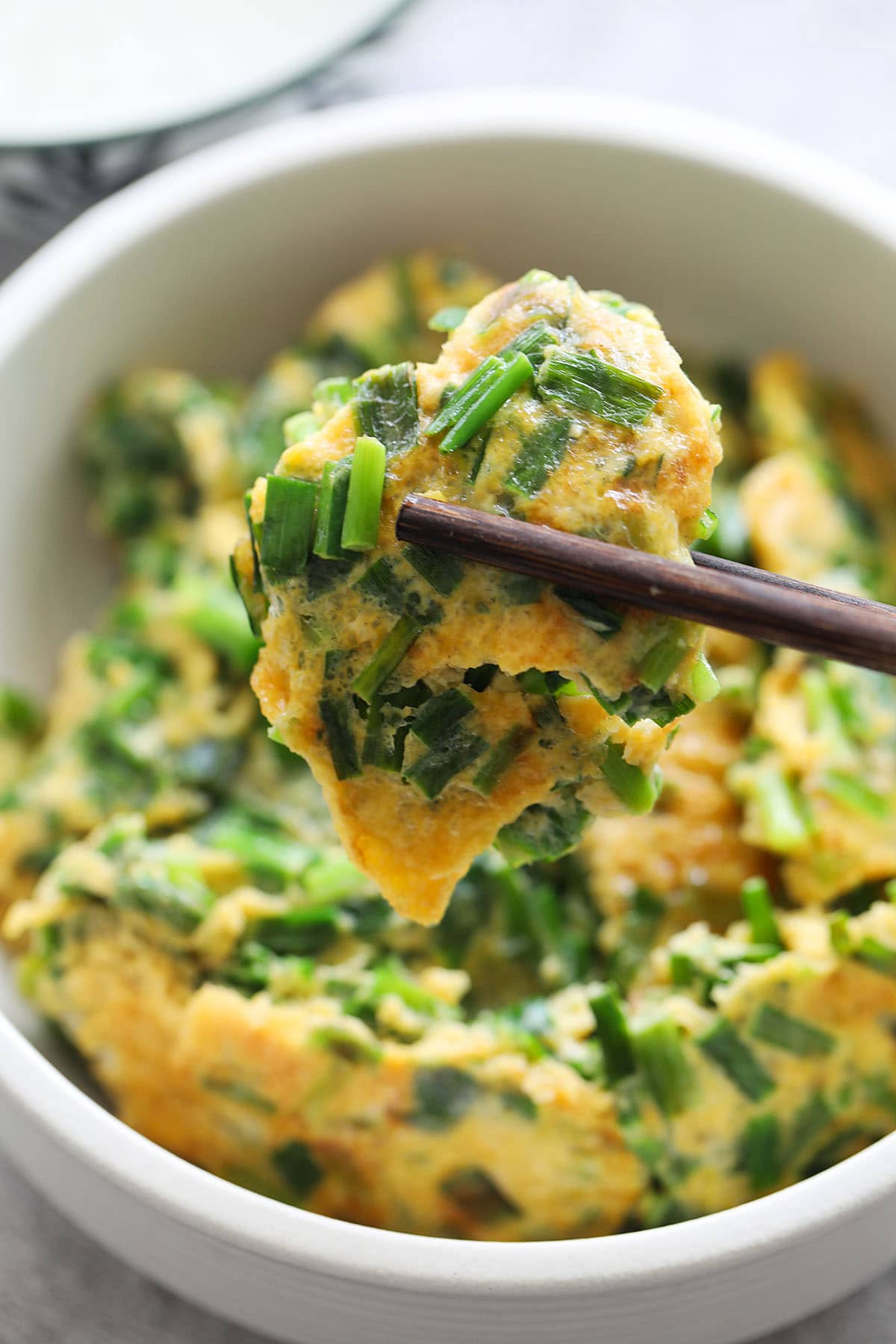 A piece of Chinese eggs and chives with chopstick. 