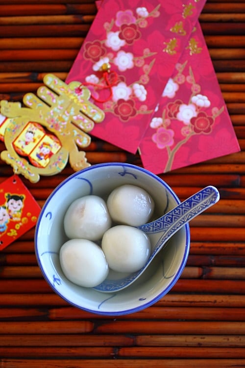 Easy and quick homemade Chinese mochi tang yuan filled with peanuts in ginger syrup served in a bowl.