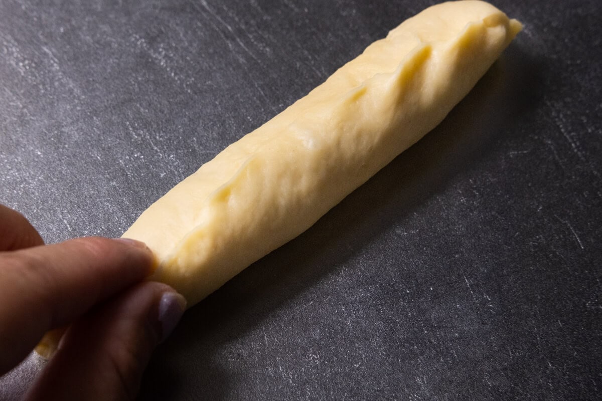 Shaping cheese bread stick dough into 8-10 inches long log. 