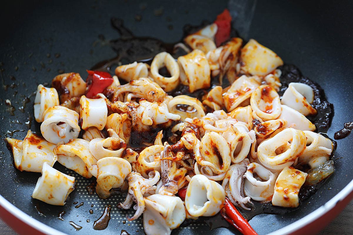 Cooking squid Thai style with chili paste and chilies. 