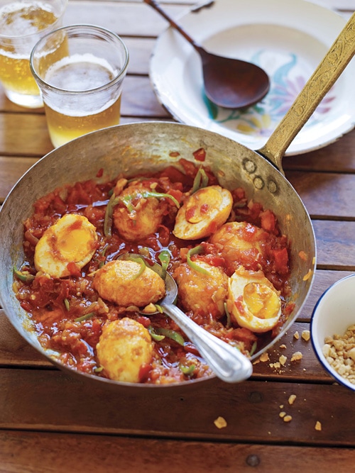 Delicious and easy homemade Burmese golden egg curry with spicy red tomato curry sauce in a skillet.