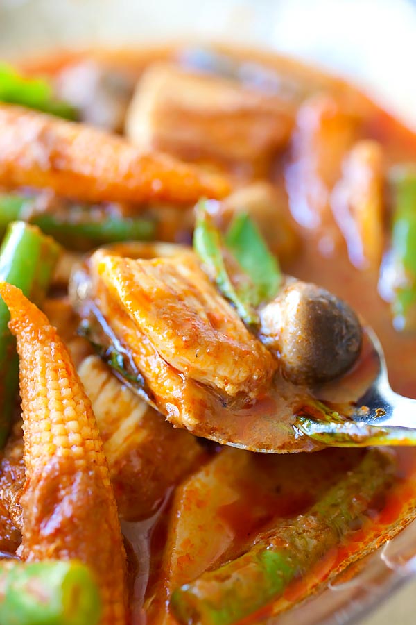 Thai jungle curry with chicken and vegetables scooped with a spoon.