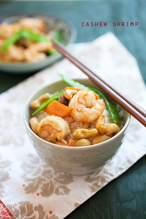 Easy and healthy Chinese stir-fry shrimp with cashew nuts in brown Chinese sauce, served on top of a bowl of steamed rice.