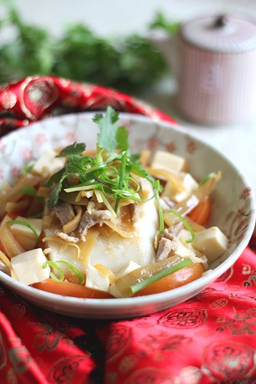 Authentic classic Teochew steamed fish made with tomatoes, fish slices, tofu, ginger and Chinese sauce.