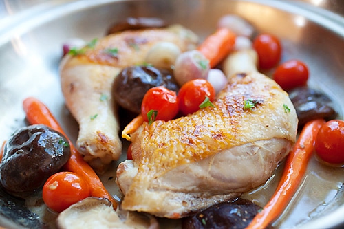 Braised chicken with carrot and mushroom in a skillet.