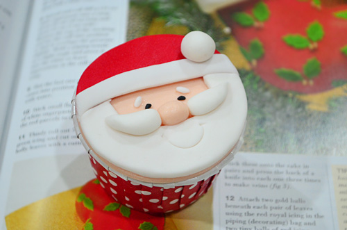 Easy homemade Christmas cupcakes with santa claus design, place on top of a magazine.