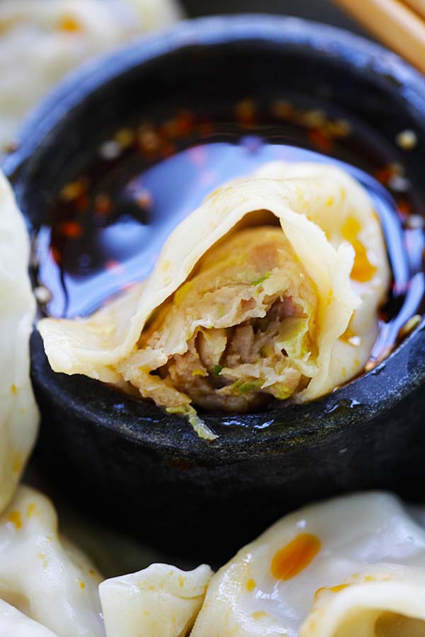 Close up homemade Chinese dumpling in half filled with pork, shrimp and napa cabbage.