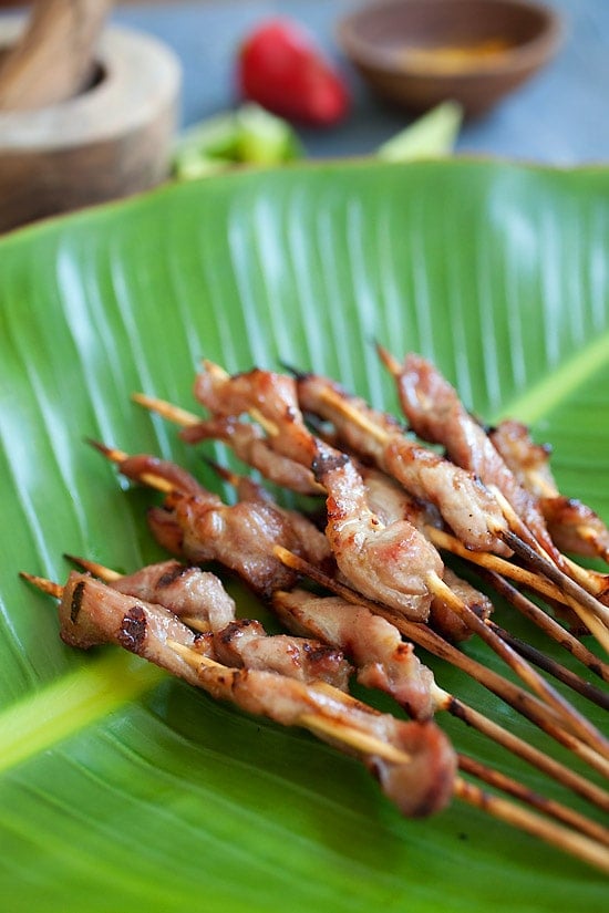 Thai pork satay with sweet coconut milk glaze on top of banana leave.