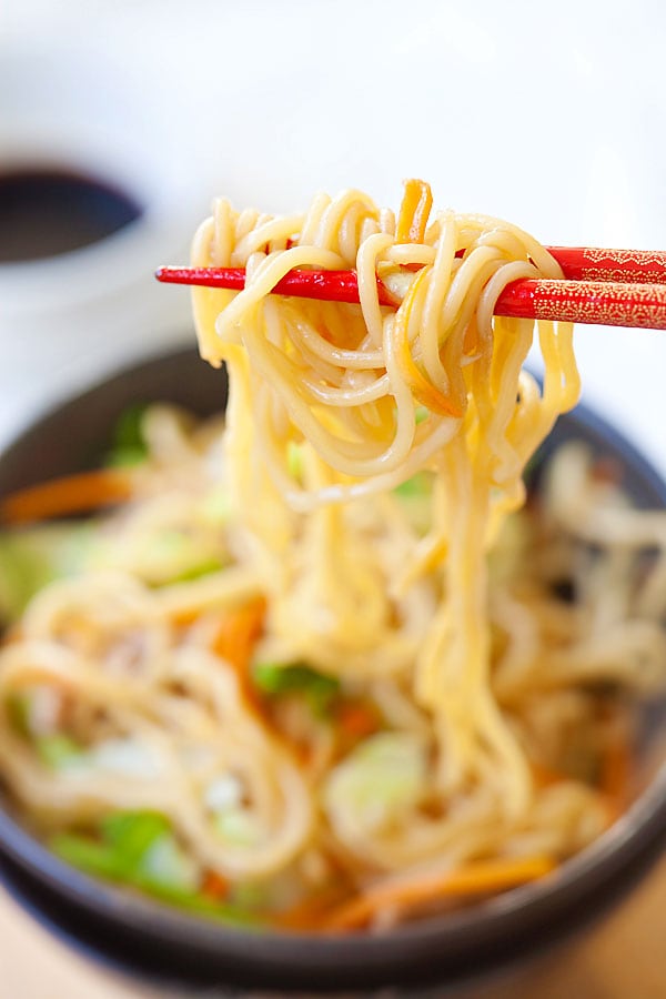 Yakisoba or Japanese fried noodles picked with a pair of chopsticks in a bowl ready to serve.