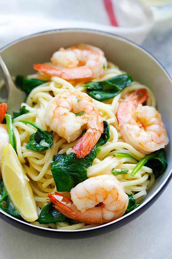 Quick and easy homemade spaghetti with shrimp and spinach in garlic butter sauce serve in a plate.