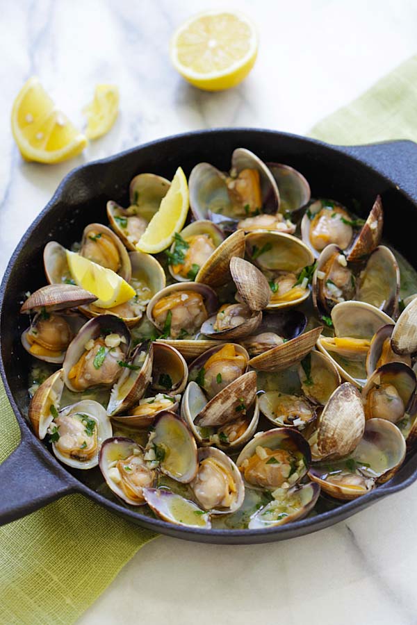 Sauteed clams with garlic butter, white wine and parsley in a skillet.