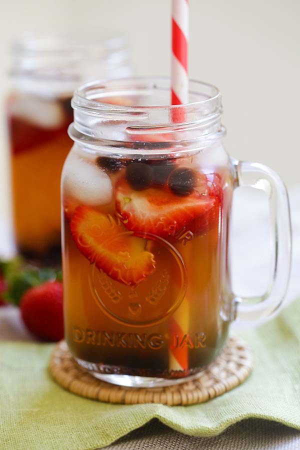 Healthy and refreshing summer iced green tea with strawberry and tapioca pearl boba served in a jar glass.