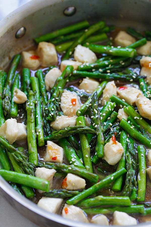 Healthy asparagus chicken stir-fry with a savory brown sauce and sweet chili sauce.