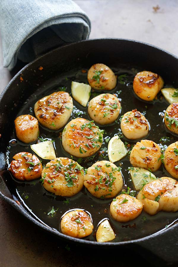 Brown butter honey garlic seared scallops in a skillet.