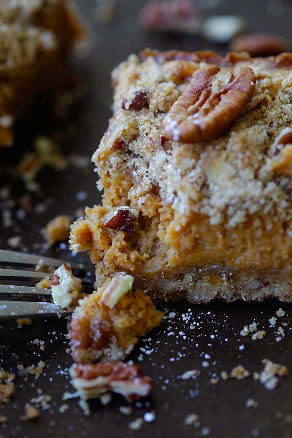 Easy homemade creamy pumpkin pecan cheesecake bar with a fork.