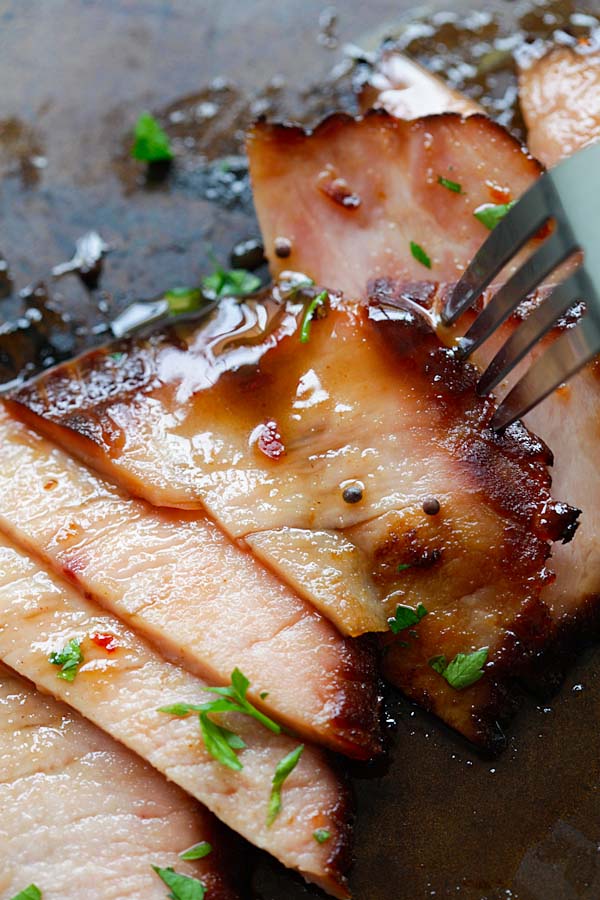 Close up picture of glazed honey ham, with a fork.