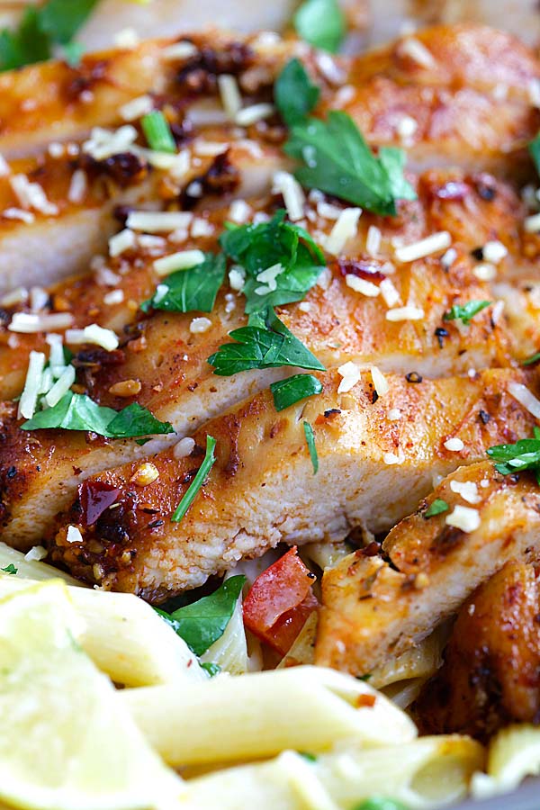 Close up easy blackened chicken with cajun marinade on top of creamy pasta ready to serve.