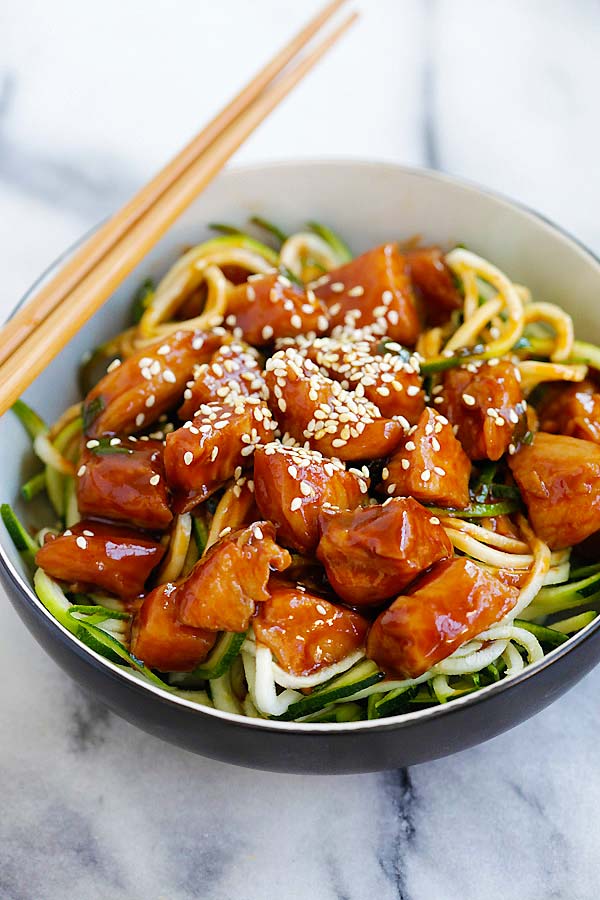 Healthy zucchini zoodles with sweet and spicy honey sriracha chicken on top.