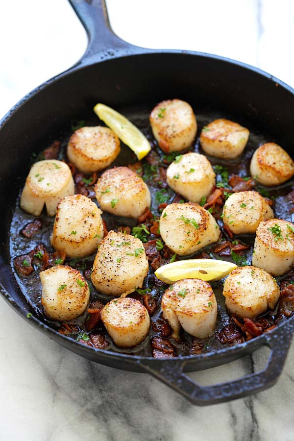 Easy and quick seared scallops with crispy bacon sauteed in butter and lemon in a skillet.