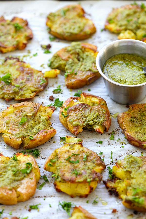 Easy and quick garlic pesto with baked smashed baby potatoes topped with delicious garlic pesto placed on a baking sheet.