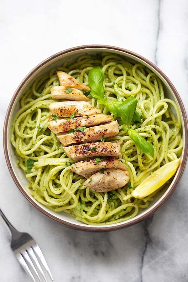 Easy and quick spaghetti pasta with basil pesto and grilled chicken in a bowl.