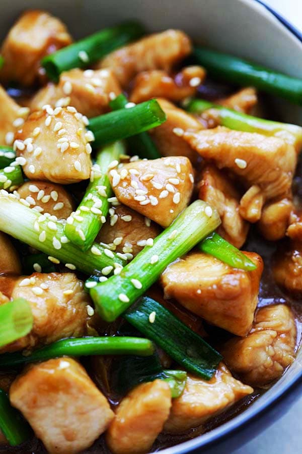 Close up easy tender and juicy Chinese chicken stir-fry with scallions and brown sauce, ready to serve.