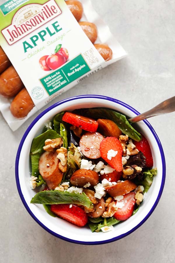 Apple Chicken Sausage Salad made with spring mix greens, sliced strawberries, walnuts and feta cheese.