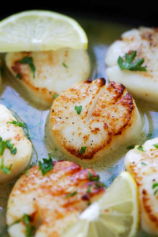 Close up juicy garlic butter scallops with lemon sauce.