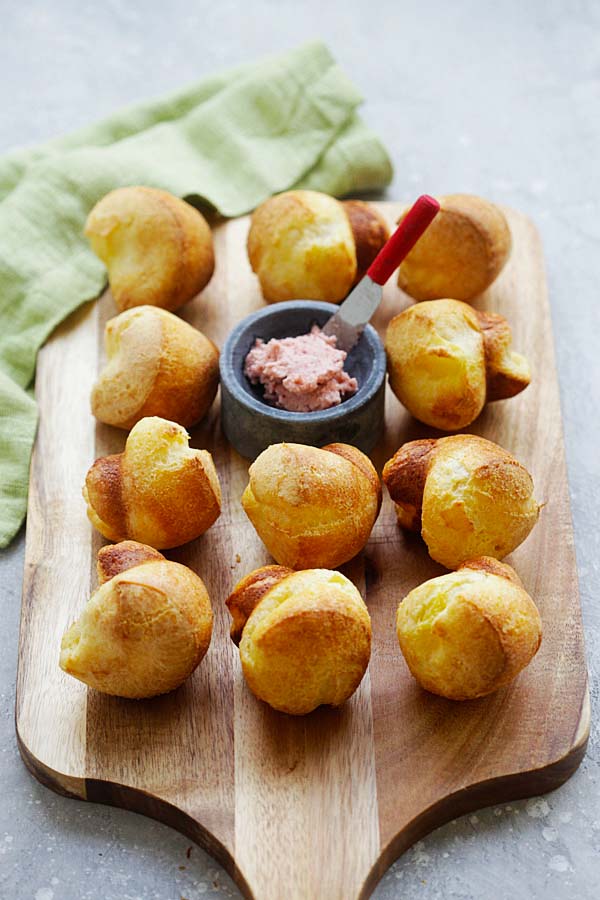 Easy and quick Yorkshire Popovers with homemade Strawberry Butter on a wooden chopping board.