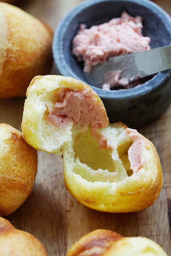 Spreading Strawberry Butter onto popovers.