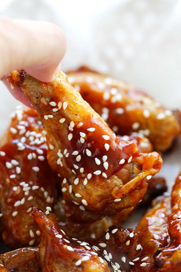 Sweet and Sour baked crispy chicken wings picked with fingers.