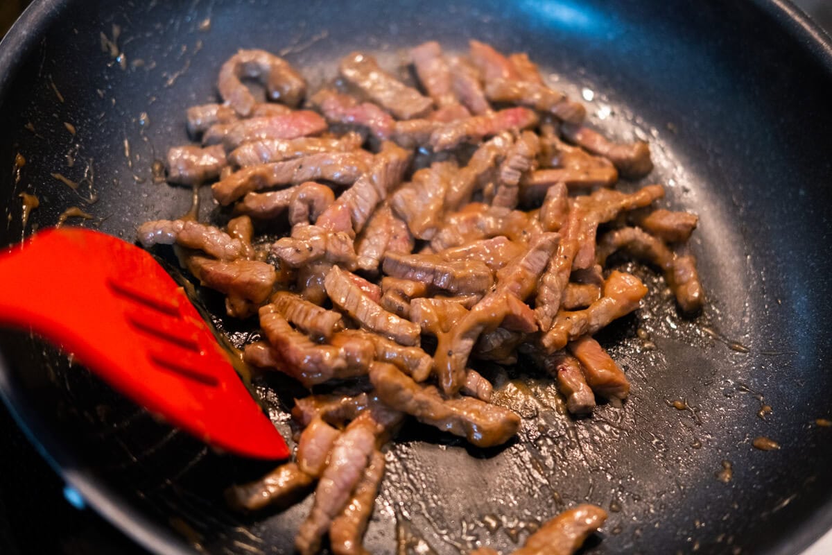 Stir fry the beef in a wok. 