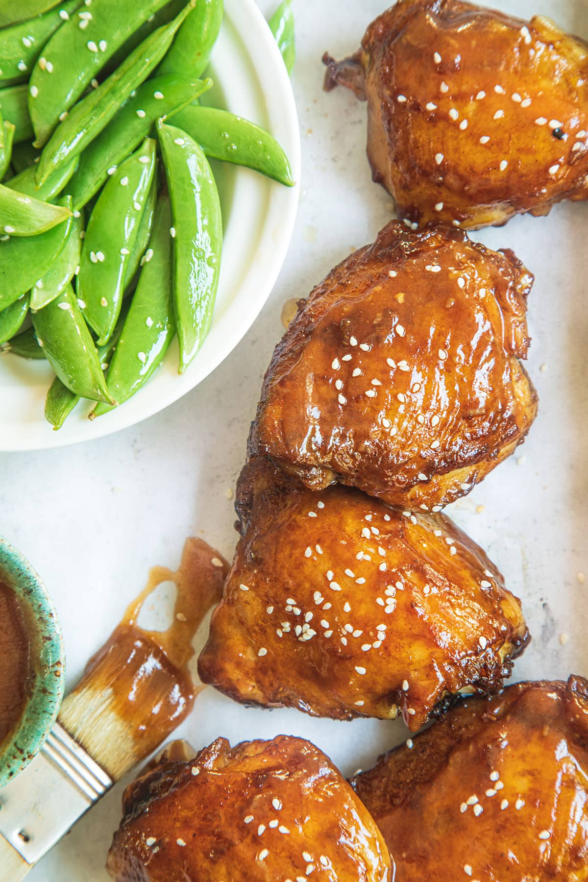 Freshly baked from oven chicken thighs marinated with honey, soy sauce, ginger, garlic in aluminium foil.