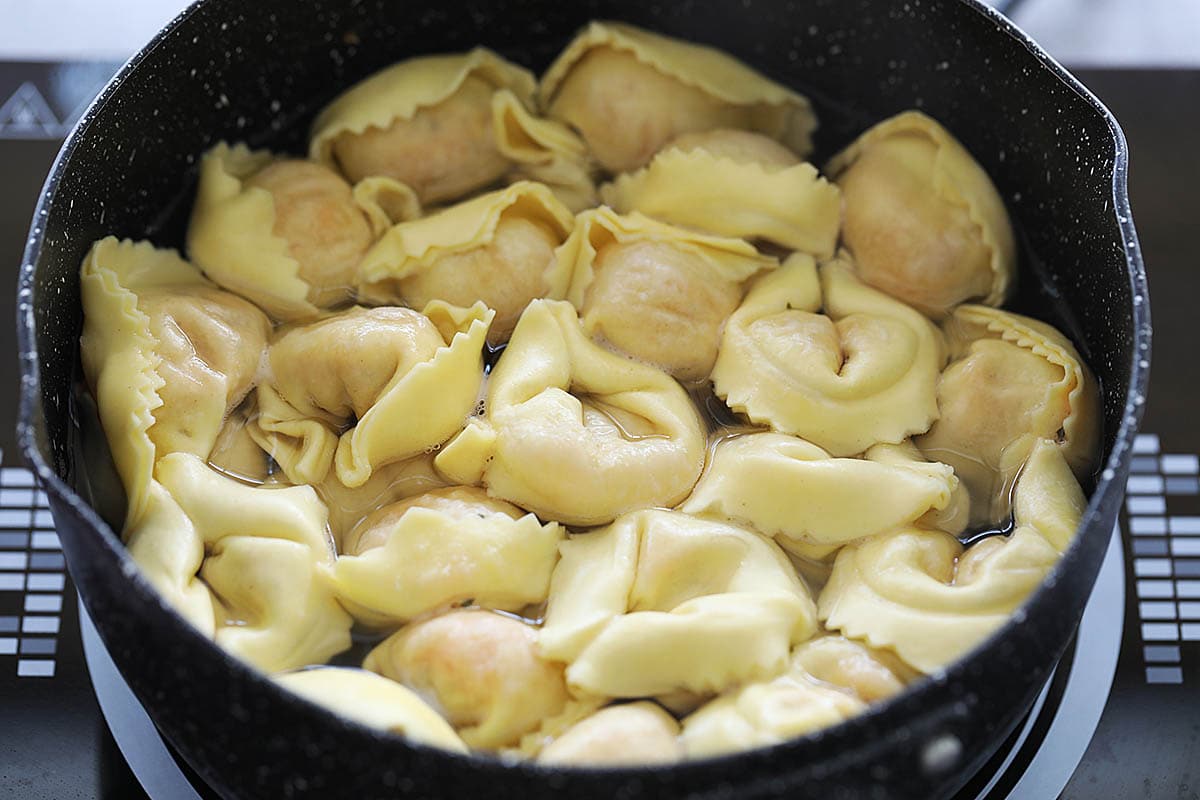 Cooking tortellini in a small pot. 