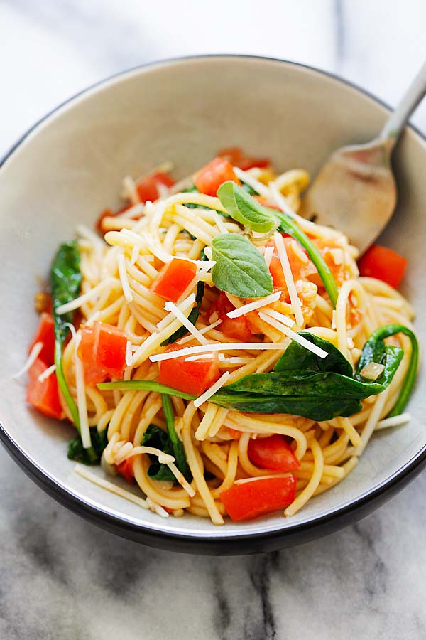 Easy and quick one-pot spaghetti pasta with spinach and tomatoes serve in a plate.