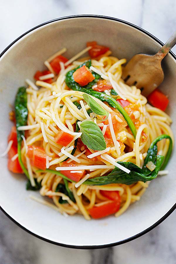 Healthy and delicious spinach and tomatoes pasta in served in a pasta bowl.