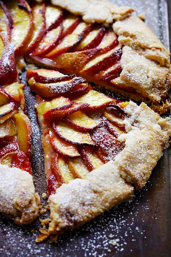 A slice of peach tart on a baking sheet.