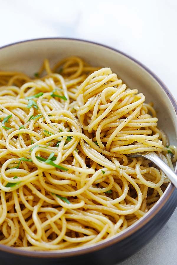 Easy and healthy homemade noodles with garlic, brown butter, Parmesan cheese and oyster sauce, served in a plate with a fork.