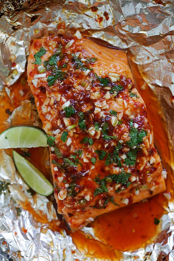 Top down view of chili lime salmon wrapped in aluminium foil, ready to serve.