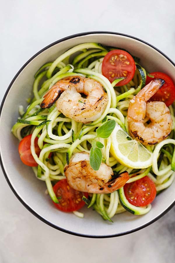 Top down view of zucchini noodle salad with lemon-honey dressing in a bowl.