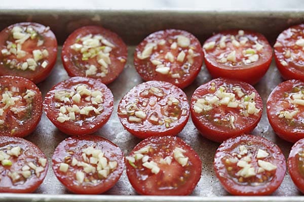 Sprinkle salt, pepper and minced garlic on the tomatoes.