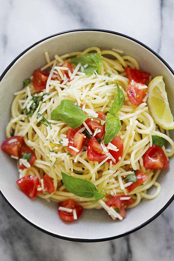 Healthy and delicious spaghetti pasta with tomatoes, fresh basil, Parmesan cheese and lemon sauce.